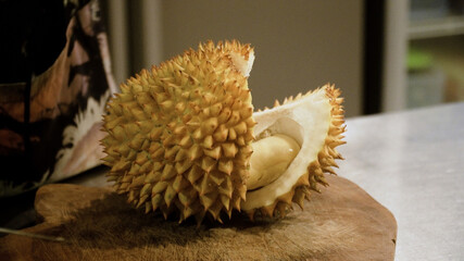 hand peeling and cuts durian fruit. caucasian man peeling durian in kitchen room