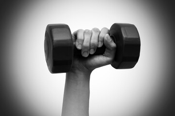 Fototapeta na wymiar Woman's hand holding dumbbell on right hand. Black and white tone. Isolated on white background. Work out concept