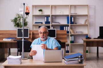 Old male employee in blood transfusion concept