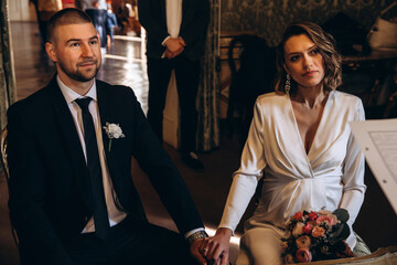 Bride and groom with a wedding bouquet. Summer sunny day.