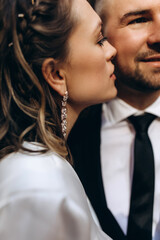 Walking the bride and groom in the fresh air. Facial portrait of a guy and a girl. Warm embrace.
