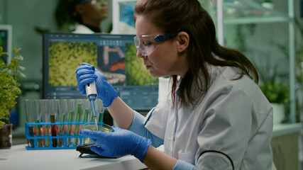 Biologist researcher using micropipette and petri dish to discovering gmo solution. Scientist...