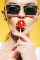 hot beautiful woman licking red lollipop in sunglasses