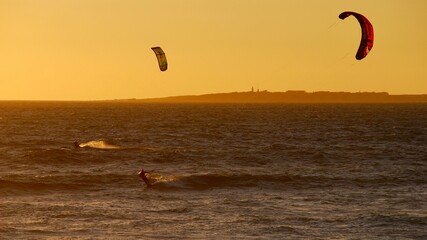 Kite surfing in Cape Town at sunset with Robben Island in the back