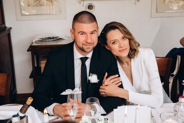 The bride and groom at the wedding table are receiving congratulations. European wedding.