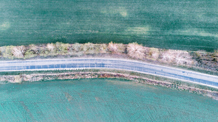 Top view of the country road, forest and field. Aerial view.