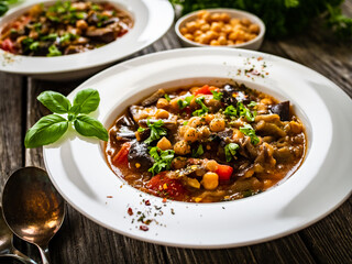 Delicious stew - aubergine with tomatoes and chickpeas on wooden table
