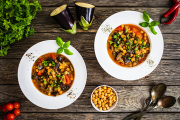 Delicious stew - aubergine with tomatoes and chickpeas on wooden table
