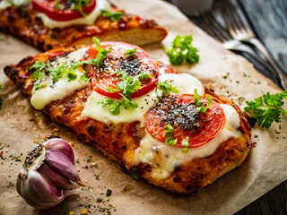 Focaccia - roasted sandwiches with mozzarella and  tomatoes on wooden background

