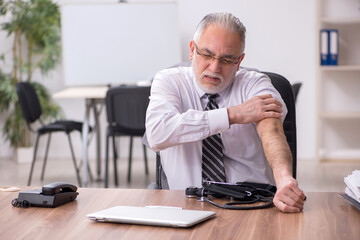 Aged male employee suffering at workplace