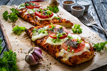 Focaccia - roasted sandwiches with mozzarella and  tomatoes on wooden background
