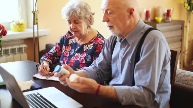 Senior couple consulting with a doctor on laptop at home
