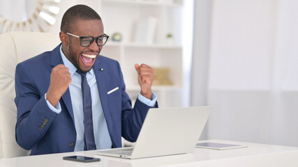 Fototapeta premium Winning, African Businessman Celebrating Success on Laptop 