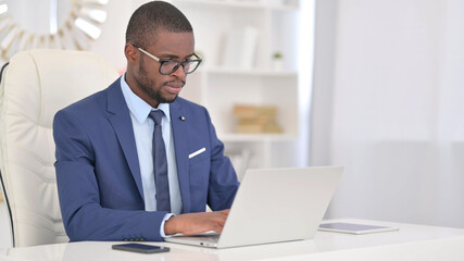 Attractive Young African Businessman Working on Laptop in Office 