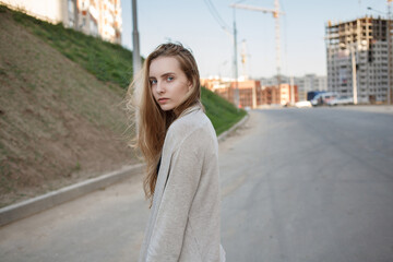 caucasian skinny female with brown hair outdoors in front of construction site