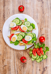 Fried bread toasts with vegetable and egg slices and salad