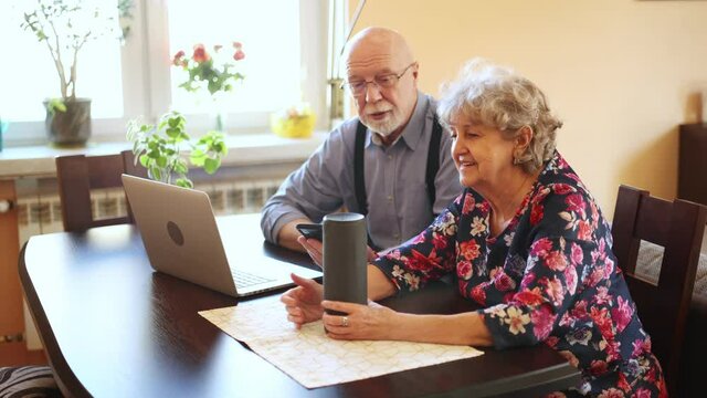 Excited senior couple using a Virtual Assistant at home
