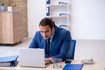 Fototapeta premium Young male employee in e-commerce concept