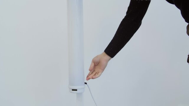 Man's hand turn on ultraviolet antibacterial bactericidal quartz medicine lamp in office.