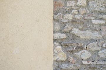 parete di sassi e cemento verniciato di giallo