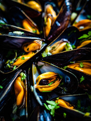 Cooked mussels with lemon and parsley on wooden table 