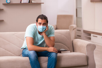 Fototapeta premium Young man sitting at home during pandemic