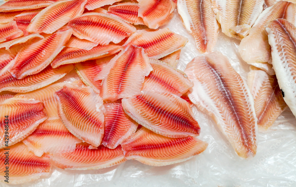 Sticker Red fillet of tilapia fish on the counter