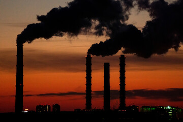 Smoke from industrial chimneys at sunset. Toxic smoke from a thermal power plant in an industrial...