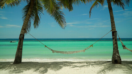 Beautiful tropical island with sand beach and hammock. Panglao, Philippines. Seascape with beautiful beach and palm trees.