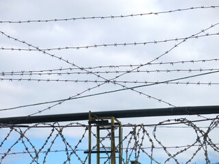 concrete fence with barbed wire at the top, prison or industrial zone