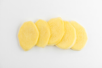 Top view on slices of ginger root on white background