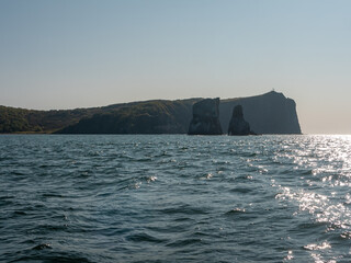 Exit on a yacht to the Avacha Bay of the Pacific Ocean. Sun glare plays on the waves against the...