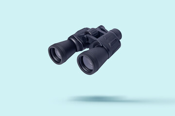 Flying binoculars on a light background. Binoculars are flying. Levitation