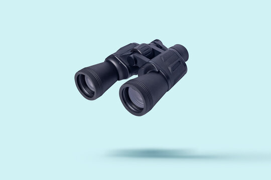 Flying binoculars on a light background. Binoculars are flying. Levitation