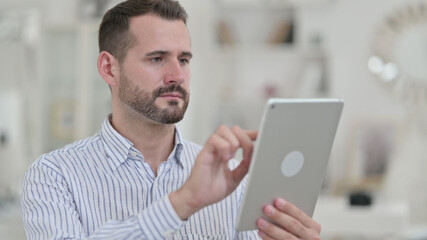 Portrait of Ambitious Young Man using Digital Tablet