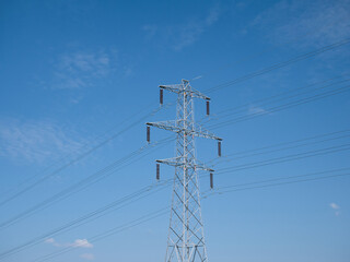 A high voltage electricity transmission pylon - part of the national grid for the distribution of power by overhead cables in the UK. Taken on a sunny day with a blue sky.