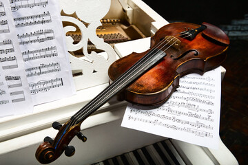 Violin and sheet music on the white grand piano