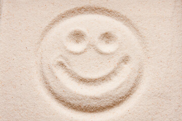 Smile face sign on the sand.