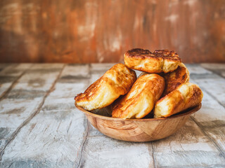 Fried pies in a deep bamboo plate on the kitchen table