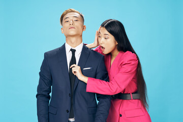 a woman in a dress straightens a tie on a business man in a suit