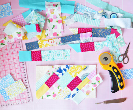 Creative mess: fabric scraps, scissors, rotary cutter, seam ripper, quilting ruler and cutting mat