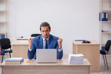 Young male employee and too much work in the office