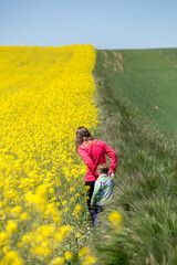 Madre e hijo disfrutando en los campos de colza amarillos