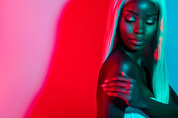 Photo of young gorgeous stunning lovely afro woman touching shoulder body care isolated on colorful glowing background © Beauty Hero