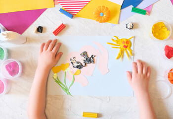 Child making card from colorful paper and plasticine. Card for International  Homeless Animals day. Pets adoption concept. Explain to the child through play and creativity about important things