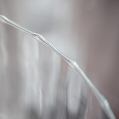 Der gewellte Rand eines Glases bildet ein grafisches Element in einem Quadrat.