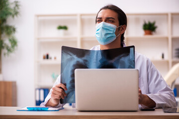 Young male doctor radiologist wearing face-mask during pandemic