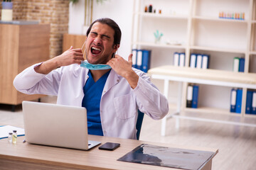 Young male doctor wearing face-mask during pandemic