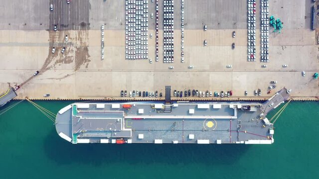 Aerial view Ro-Ro Ship of business logistic sea freight, New Cars produced by year up in the port for Cargo ship and Cargo import-export around in the world. cargo ship. 4K 