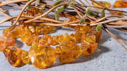 Dazzling glittering bright yellow Baltic amber necklace on a gray background. Ancient amber stone  is a strong talisman, healing, protection, powers and love. 